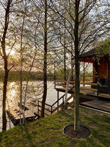 a log cabin with a dock next to a lake at On The River in Vishenki