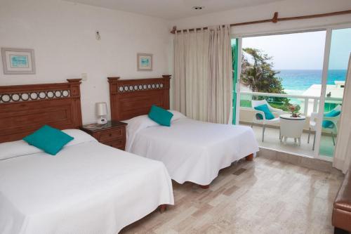 2 camas en una habitación con vistas al océano en Cancun Beach Aparthotel Brisas, en Cancún