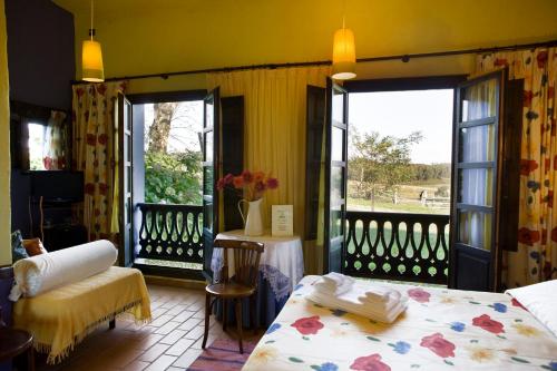 a room with two beds and a balcony with a view at Hotel Rural La Llosa de Fombona in Luanco