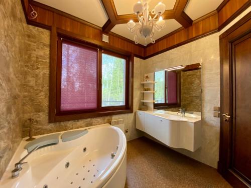 a large bathroom with a tub and a sink at On The River in Vishenki