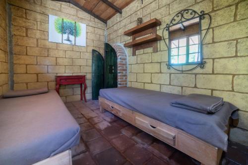 a bedroom with two beds and a brick wall at HOTEL XIADANI Restaurante, Temazcal & Spa in Tlaxcala de Xicohténcatl
