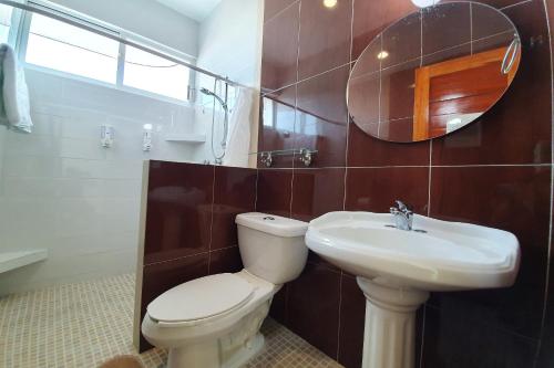 a bathroom with a toilet and a sink and a mirror at Casa Mia in Puerto Escondido