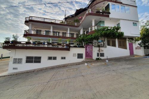 a white building with balconies on the side of it at Casa Mia in Puerto Escondido