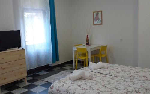 1 dormitorio con cama, mesa y TV en Rezi, en Slap ob Idrijci