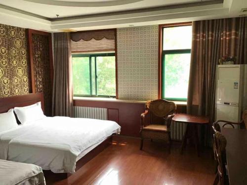 a bedroom with two beds and a chair and a window at 7days Inn·Zibo Zhoucun Taoyuan Ginza Branch in Zibo