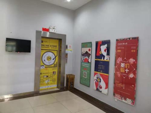 a waiting room with a clock and posters on the wall at 7Days Inn Qingzhou Pingzhangfu Store in Weifang