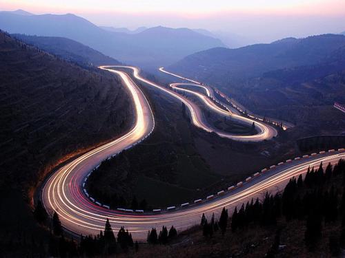 a winding road in the mountains with lights on at 7Days Inn Qingzhou Pingzhangfu Store in Weifang