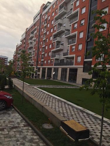 a sidewalk in front of some tall buildings at Blini Complex in Pristina