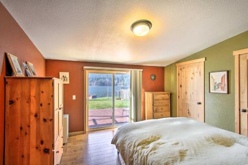 1 dormitorio con cama y ventana grande en Lakefront Cabin with Stunning Mountain Views and Dock! en Mineral