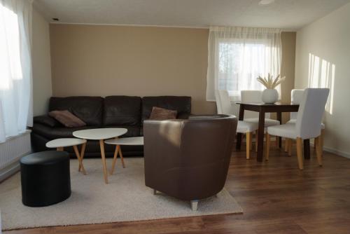 a living room with a couch and a table and chairs at Modern chalet at holiday park in Opmeer near Amsterdam in Opmeer