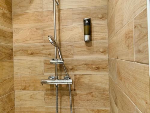 une douche dans une salle de bain avec un mur en bois dans l'établissement Zola Studio fenêtre aveugle, à Aix-en-Provence