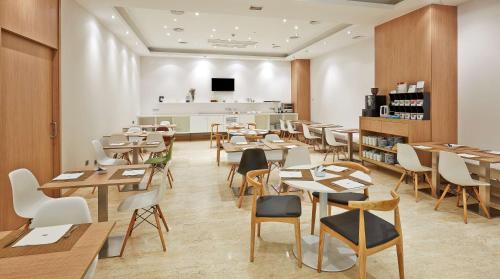 a restaurant with tables and chairs in a room at NH Bilbao Deusto in Bilbao
