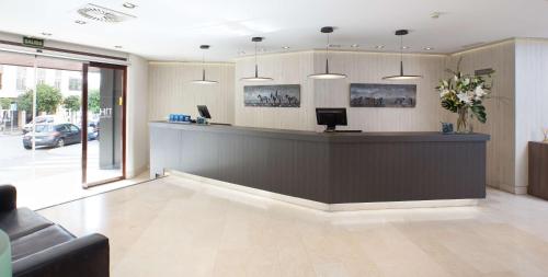 a lobby with a reception desk in a building at NH Córdoba Califa in Córdoba