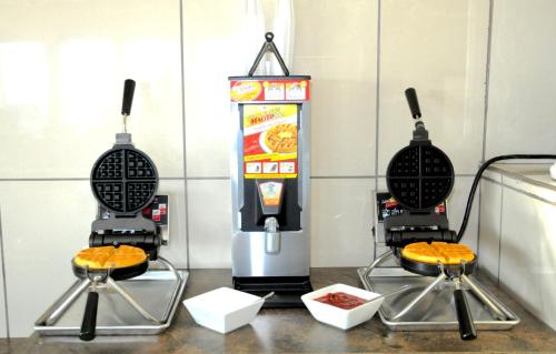 two microwaves sitting on top of a counter with food at High Point Inn & Suites Peace River in Peace River