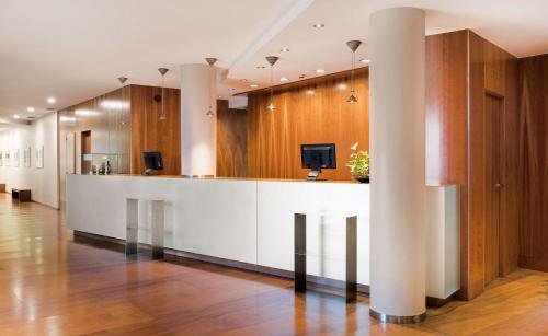 a lobby with a bar with a tv on it at NH Zamora Palacio del Duero in Zamora