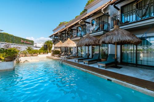 a hotel with a swimming pool in front of a building at Caribbean Paradise Hotel Boutique & Spa by Paradise Hotels - 5th Av Playa del Carmen in Playa del Carmen