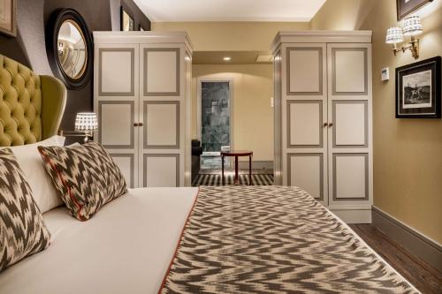 a bedroom with a king sized bed with a yellow headboard at NH Collection Colón Valencia in Valencia