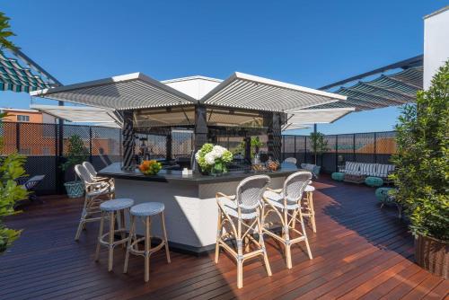 a patio with a bar with stools on a deck at NH Collection Colón Valencia in Valencia