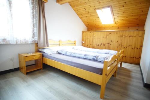 サースフェーにあるChalet Delphinの木製の部屋にベッド1台が備わるベッドルーム1室があります。