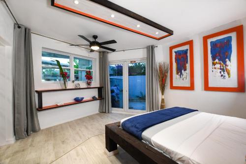 - une chambre avec un lit et un ventilateur de plafond dans l'établissement Orange Cottage - At Orange Hill, à Nassau
