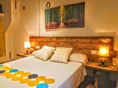 een slaapkamer met een groot bed met 2 lampen bij El moli del montseny in Fogás de Monclús