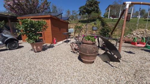 a garden with plants in pots and a playground at La Limonaia Country House in Monteriggioni