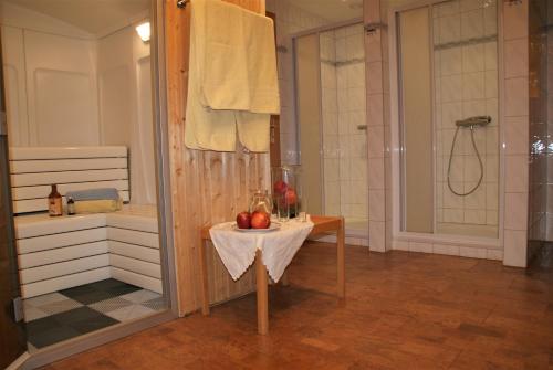 ein Bad mit einer Dusche und einem Tisch mit Äpfeln darauf in der Unterkunft Gasthof & Gästehaus Trummer in Horitschon