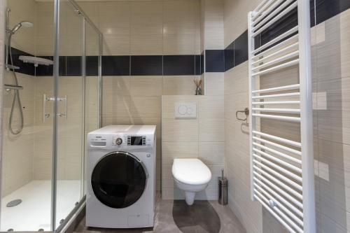 a bathroom with a washing machine and a toilet at Le 15-GregIMMO-Appart'Hôtel in Montbéliard