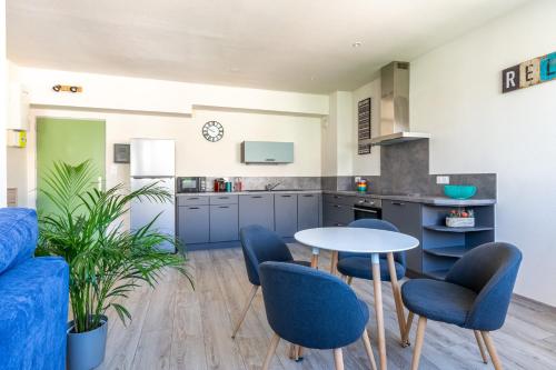 une cuisine et un salon avec une table et des chaises dans l'établissement Le 15-GregIMMO-Appart'Hôtel, à Montbéliard