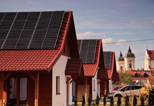 a row of houses with solar panels on their roofs at Przystanek Tykocin - domki gościnne w sercu Podlasia in Tykocin
