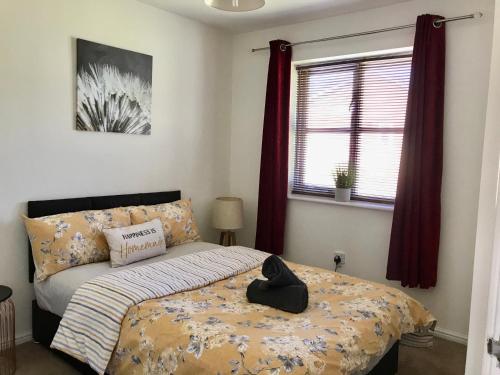a bedroom with a bed with a hat on it at Kettering Leisure Holiday Home in Kettering