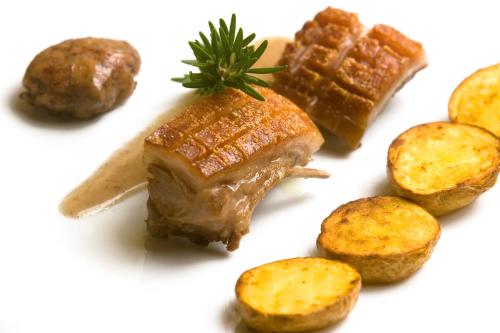 a plate of food with a piece of meat and potatoes at Sovana Hotel & Resort in Sovana