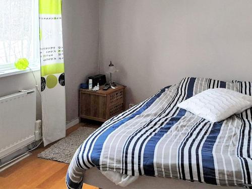 a bedroom with a bed with a blue and white striped blanket at 6 person holiday home in BOLLNÄS in Bollnäs