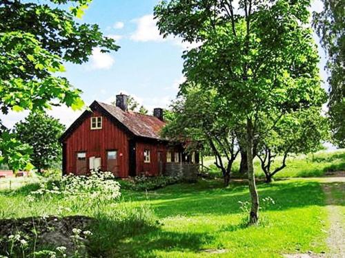 um celeiro vermelho no meio de um campo em 6 person holiday home in LOFTAHAMMAR em Loftahammar