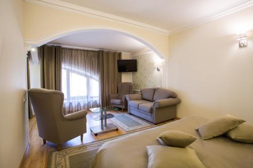 a bedroom with a bed and a chair and a couch at Spa-Hotel Myslyvskiy Dvir in Kyiv