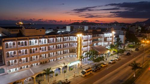 a building on a street at night with cars parked at Hotel Fiesta Mexicana in Manzanillo