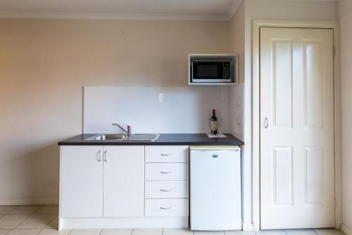 a kitchen with a sink and a microwave at Best Western Mill Park Motor Inn in Morang