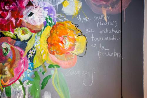a painting of a vase of flowers on a wall at Niños Hotel Meloc in Cusco