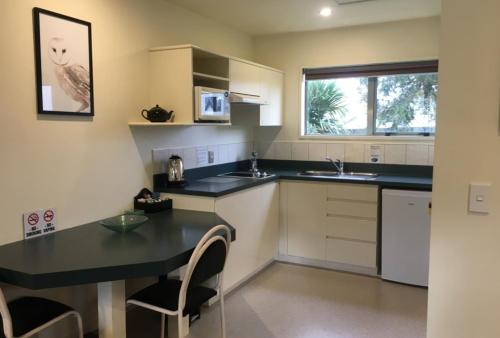 a kitchen with a table and chairs and a refrigerator at Colonial Manor Motel in Cromwell