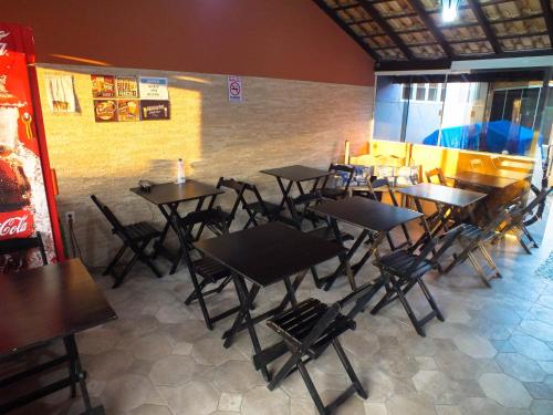 a group of tables and chairs in a restaurant at Aeropouso Pousada Executiva in Florianópolis