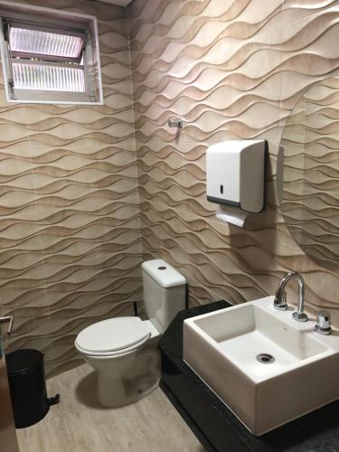 uma casa de banho com um WC, um lavatório e um espelho. em Hotel Barão em São Paulo