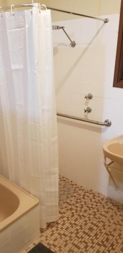 a bathroom with a white shower curtain and a sink at Warmont Apartments Self Contained Home in Whyalla