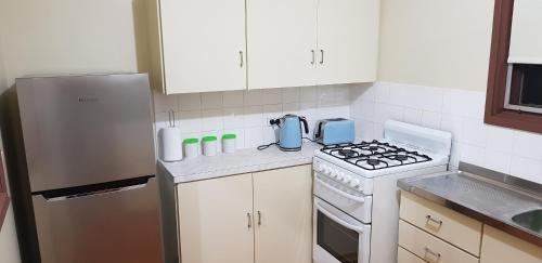 a kitchen with a stove and a refrigerator at Warmont Apartments Self Contained Home in Whyalla