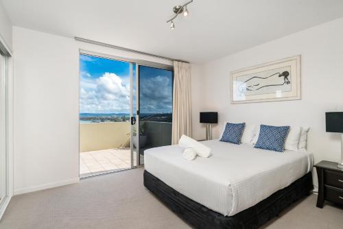 a bedroom with a bed and a sliding glass door at Grandview Apartments in Ballina