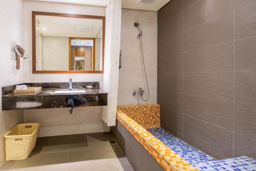 a bathroom with a shower and a sink and a mirror at Jia Hsin Garden Hotel in Tainan