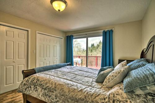a bedroom with a bed with blue curtains and a window at Charming Kelso Home with Proximity to Cowlitz River! in Kelso
