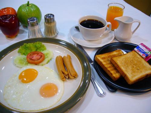 a breakfast plate with eggs and toast and a cup of coffee at Grand Business Inn in Bangkok