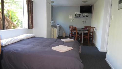 a room with a bed and a table with chairs at Ohakune Court Motel in Ohakune