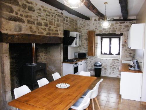 a kitchen and dining room with a wooden table and chairs at LOU CHASTEL, DEMEURE PERIGOURDINE CLIMATISEE avec PISCINE PRIVEE et CHAUFFEE in La Bachellerie