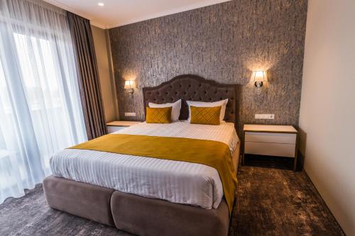 a hotel room with a large bed with yellow pillows at Hotel Aventus in Baile Felix